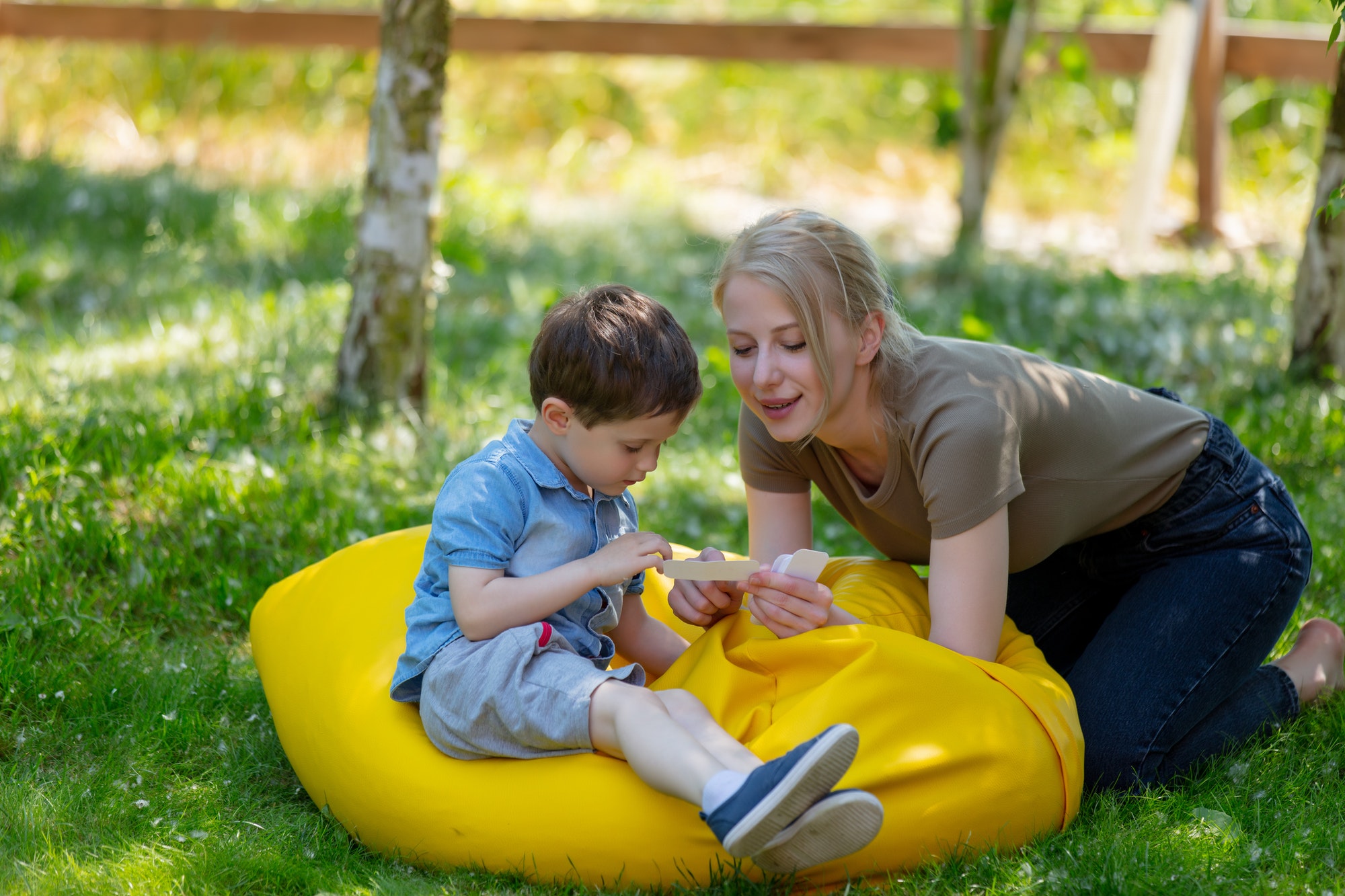 mom teaches to pronounce words using the Doman technique for an autistic child in the yard